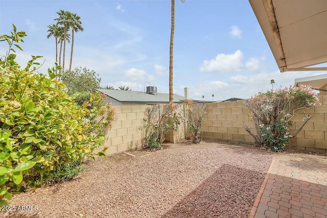 view of yard with cooling unit, a fenced backyard, and a patio area