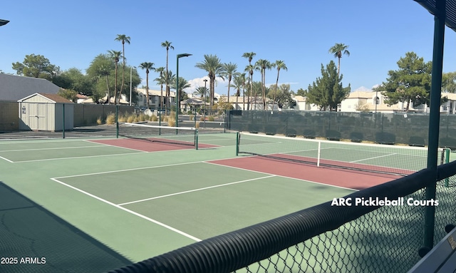 view of tennis court with a residential view, community basketball court, and fence