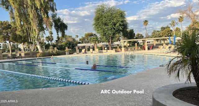 community pool with fence and a patio area