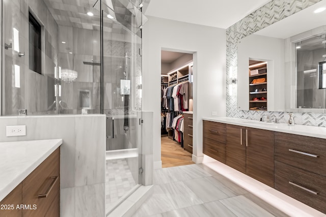 bathroom featuring vanity, backsplash, and a shower with shower door