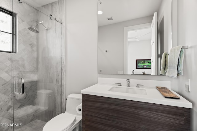 bathroom with vanity, a shower with door, and toilet