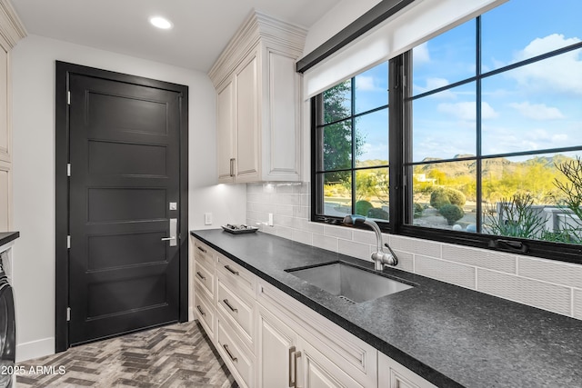 kitchen with white cabinetry, sink, and backsplash