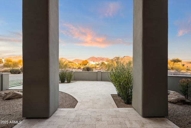 patio terrace at dusk featuring a mountain view