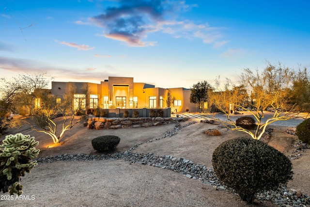 view of back house at dusk