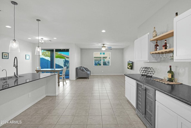 kitchen with pendant lighting, white cabinets, sink, ceiling fan, and light tile patterned flooring