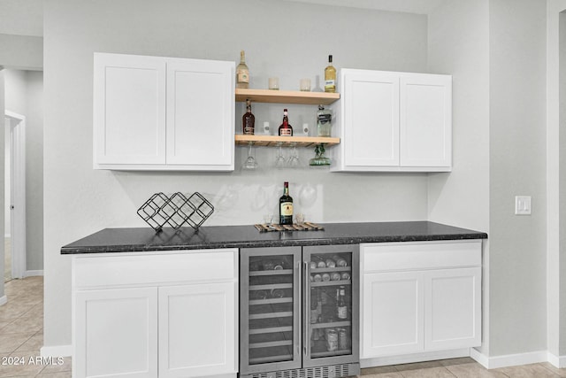 bar featuring white cabinets, beverage cooler, and light tile patterned flooring