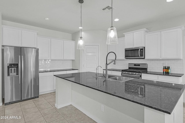 kitchen with white cabinets, sink, stainless steel appliances, and an island with sink