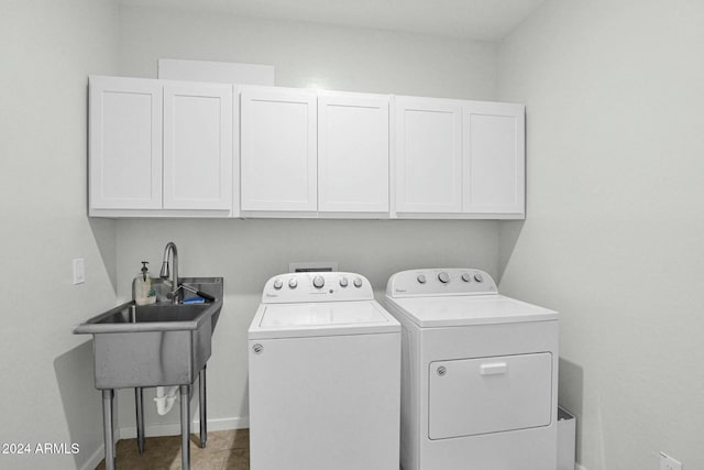 clothes washing area with cabinets and washing machine and dryer