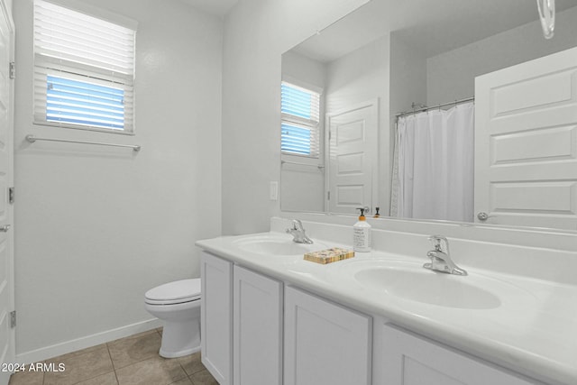 bathroom with tile patterned flooring, vanity, and toilet