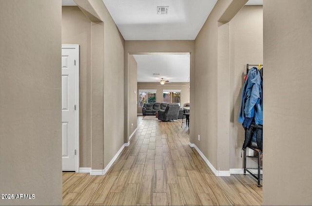 hallway with light hardwood / wood-style floors