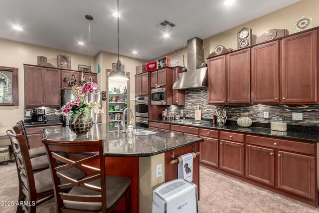 20962 W Thomas Rd, Buckeye, AZ 85396 - kitchen featuring wall chimney range hood, stainless steel appliances, decorative backsplash, a breakfast bar area, and an island with sink