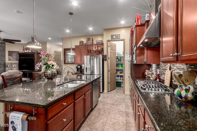 20962 W Thomas Rd, Buckeye, AZ 85396 - kitchen featuring a sink, wall chimney range hood, appliances with stainless steel finishes, decorative backsplash, and a kitchen island with sink