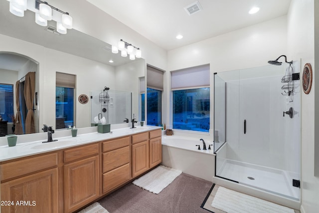 bathroom featuring a stall shower, visible vents, a sink, and a garden tub