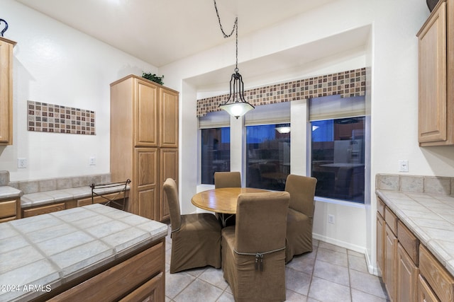 interior space featuring tile countertops, decorative light fixtures, and light tile patterned floors