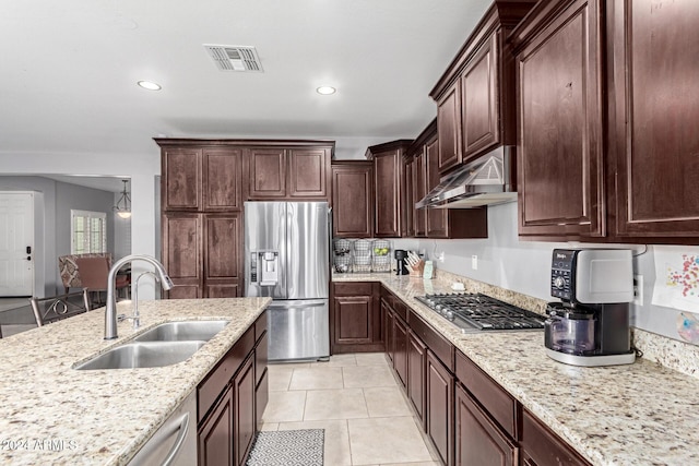 kitchen featuring sink, light stone counters, dark brown cabinets, light tile patterned floors, and appliances with stainless steel finishes