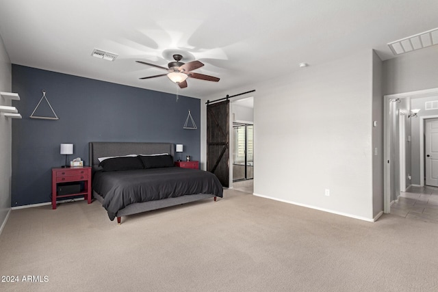 bedroom featuring carpet flooring, a barn door, and ceiling fan