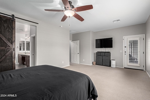 carpeted bedroom with ceiling fan, a barn door, access to outside, and connected bathroom