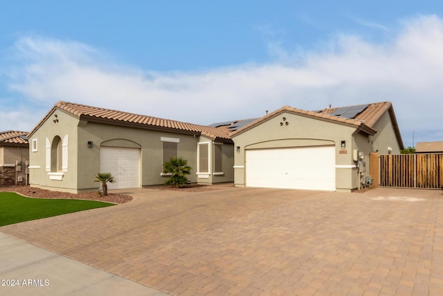 mediterranean / spanish home featuring a garage and solar panels