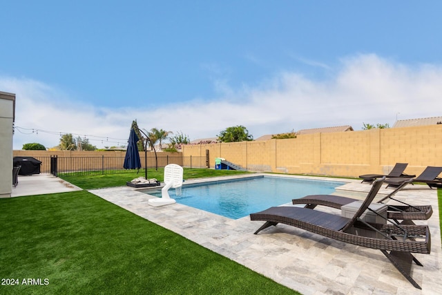 view of swimming pool featuring a yard and a patio area