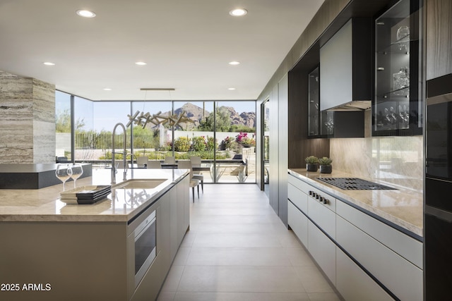 4451 E Joshua Tree Ln, Paradise Valley, AZ 85253 - kitchen featuring modern cabinets, a wall of windows, a sink, recessed lighting, and light stone countertops