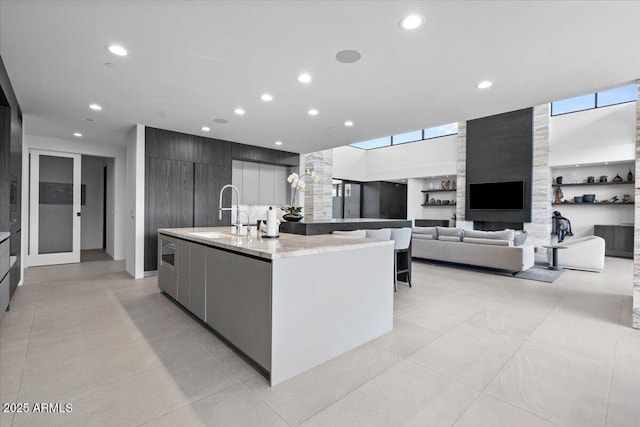4451 E Joshua Tree Ln, Paradise Valley, AZ 85253 - kitchen with a sink, modern cabinets, an island with sink, recessed lighting, and light tile patterned floors