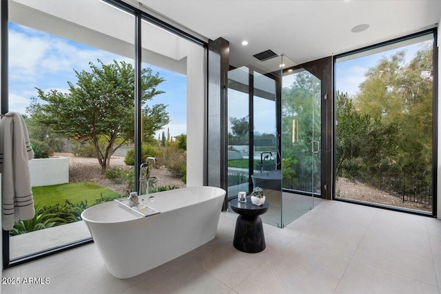 4451 E Joshua Tree Ln, Paradise Valley, AZ 85253 - bathroom featuring a wall of windows, healthy amount of natural light, a freestanding bath, and tile patterned flooring