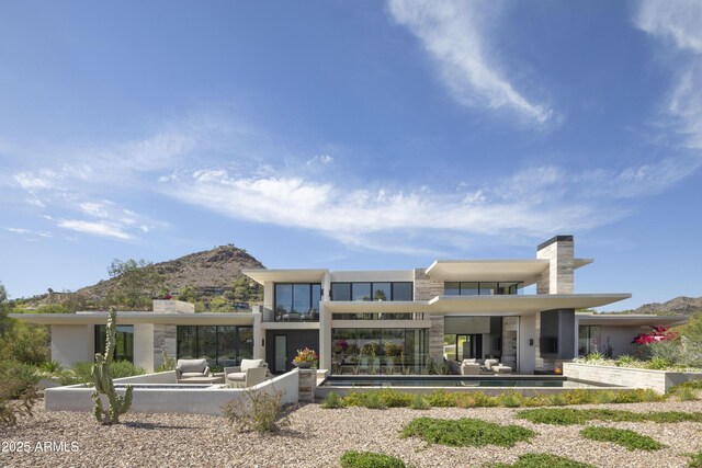 4451 E Joshua Tree Ln, Paradise Valley, AZ 85253 - back of property with a mountain view, outdoor lounge area, a patio area, and an outdoor pool