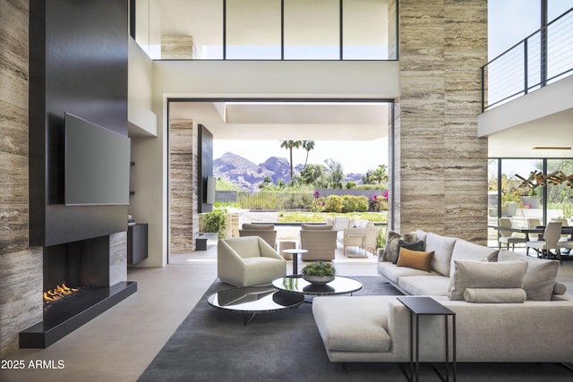 4451 E Joshua Tree Ln, Paradise Valley, AZ 85253 - living area with a high ceiling, a warm lit fireplace, and plenty of natural light