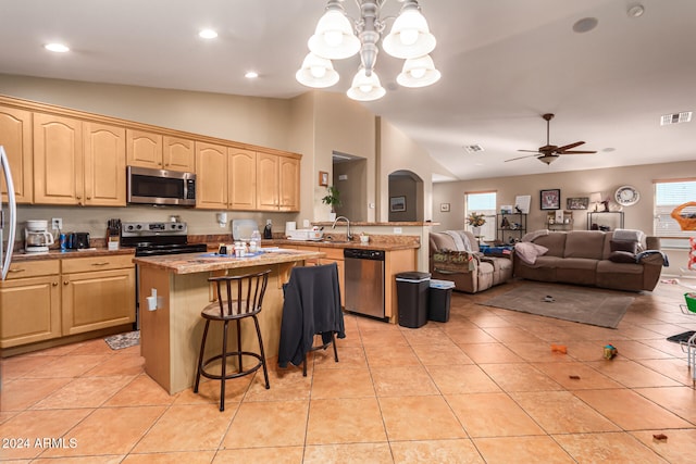 kitchen with kitchen peninsula, a breakfast bar, a center island, and stainless steel appliances