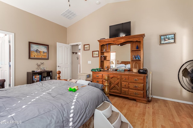 bedroom with vaulted ceiling and light hardwood / wood-style flooring