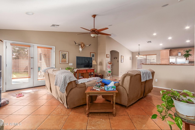 living room featuring light tile patterned floors, ceiling fan with notable chandelier, and lofted ceiling