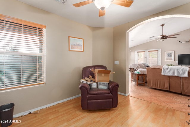 living area with light hardwood / wood-style floors and vaulted ceiling