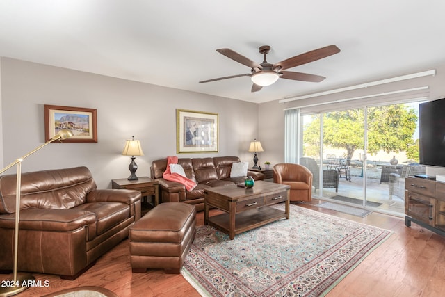 living room with ceiling fan and light hardwood / wood-style flooring