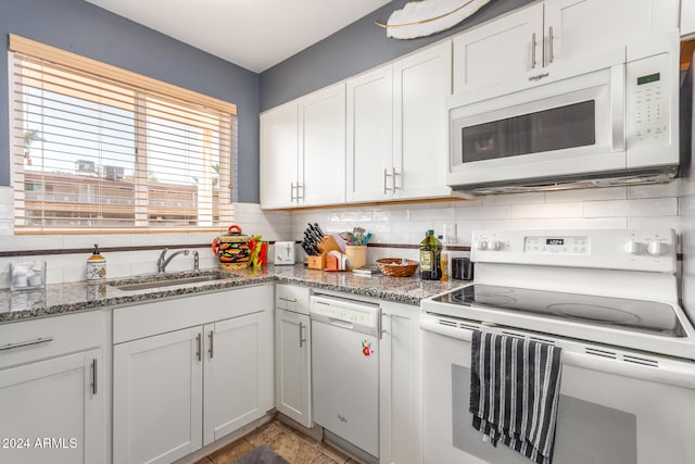 kitchen featuring white cabinetry, sink, stone countertops, and white appliances