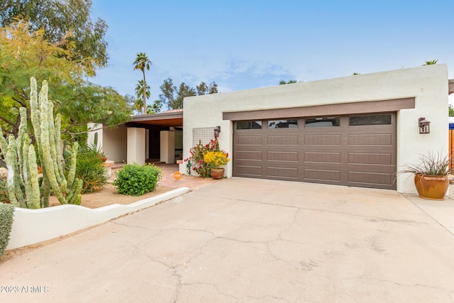 pueblo revival-style home with a garage