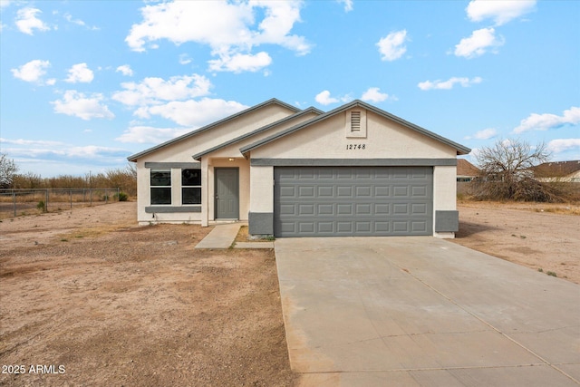 view of front of property with a garage, driveway, fence, and stucco siding