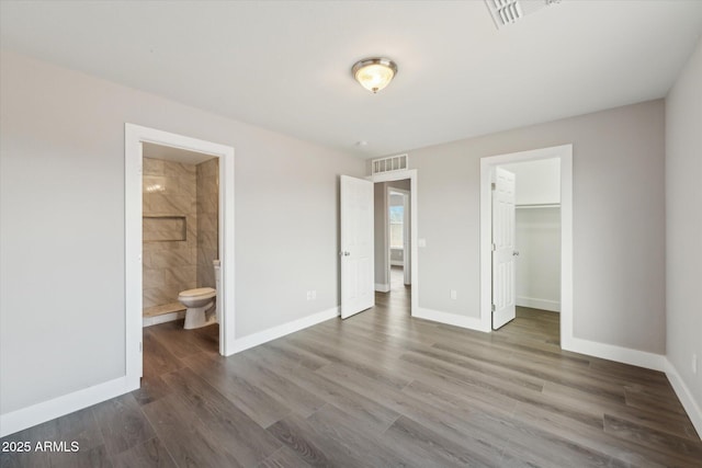 unfurnished bedroom with wood finished floors, visible vents, and baseboards