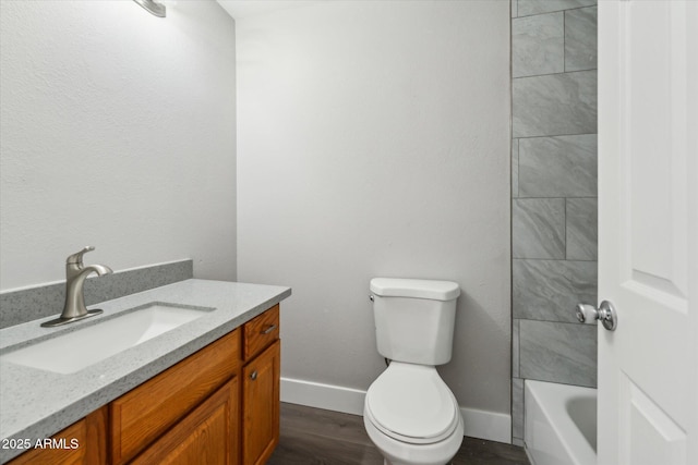 bathroom with baseboards, vanity, toilet, and wood finished floors