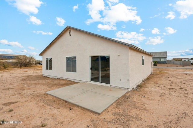 rear view of property with a patio and stucco siding