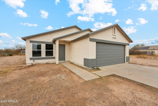 single story home with driveway, an attached garage, and stucco siding