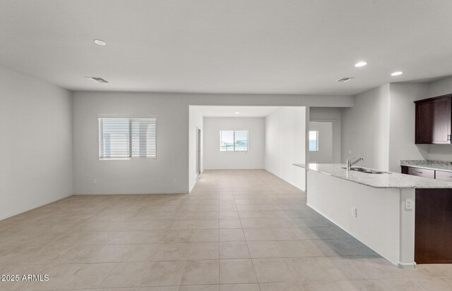 5053 S 252nd Ave, Buckeye, AZ 85326 - kitchen with open floor plan, recessed lighting, a sink, light stone counters, and visible vents