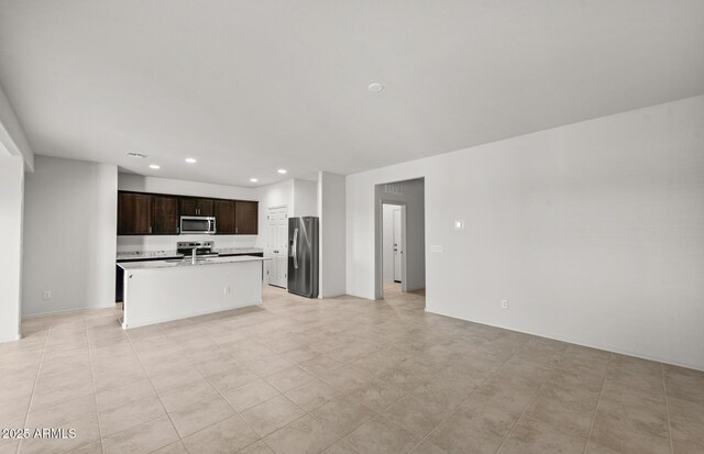 5053 S 252nd Ave, Buckeye, AZ 85326 - kitchen featuring recessed lighting, a center island with sink, dark brown cabinetry, appliances with stainless steel finishes, and open floor plan