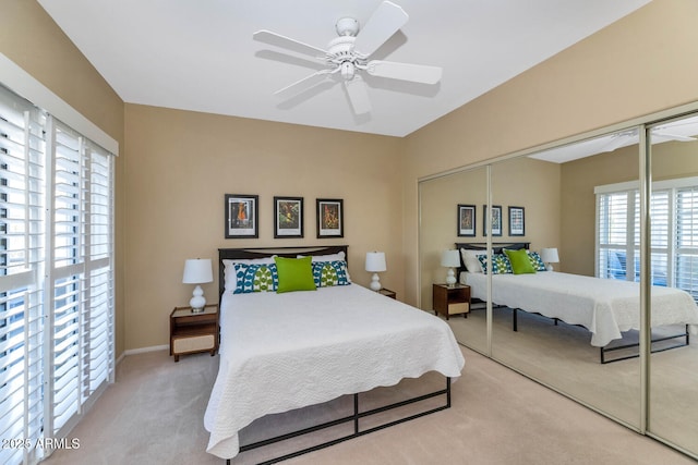 carpeted bedroom with ceiling fan and a closet