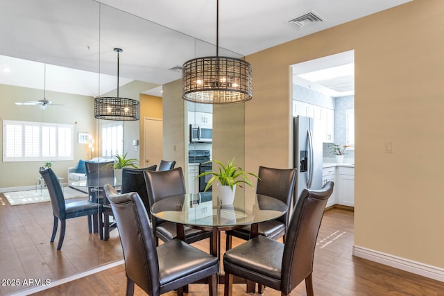 dining area with ceiling fan and hardwood / wood-style flooring