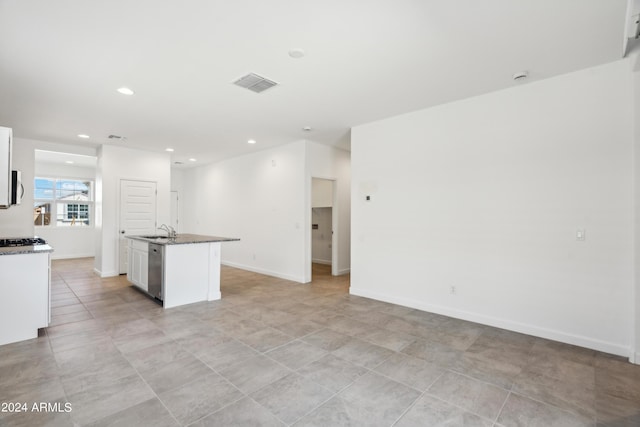 kitchen with a center island with sink, visible vents, white cabinets, a sink, and stainless steel dishwasher