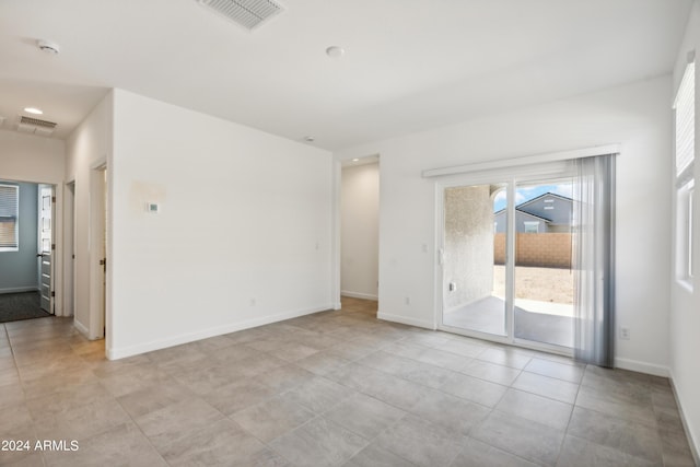 spare room with light tile patterned floors, baseboards, and visible vents