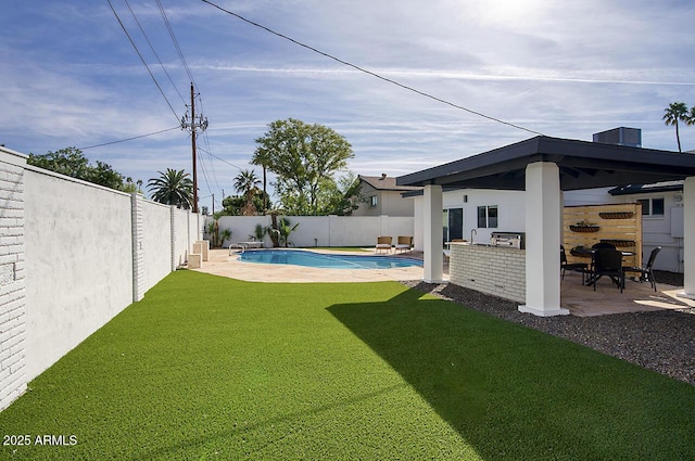6325 N 83rd Pl, Scottsdale, AZ 85250 - view of yard with a fenced in pool, a fenced backyard, a patio area, and exterior kitchen