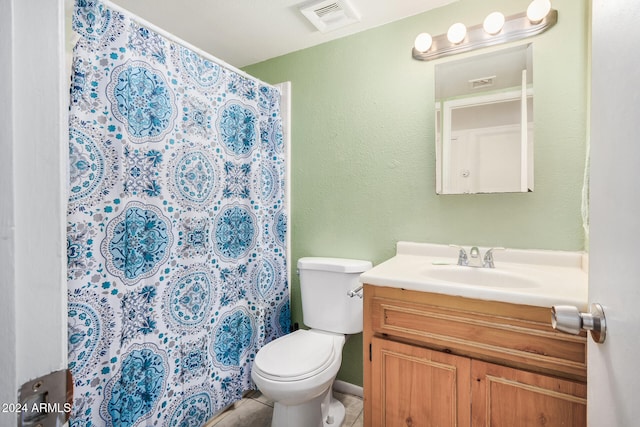 bathroom with tile patterned floors, vanity, toilet, and walk in shower