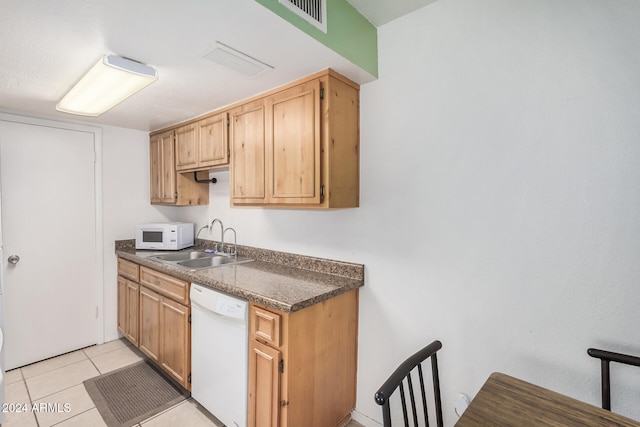 kitchen featuring light tile patterned floors, white appliances, and sink