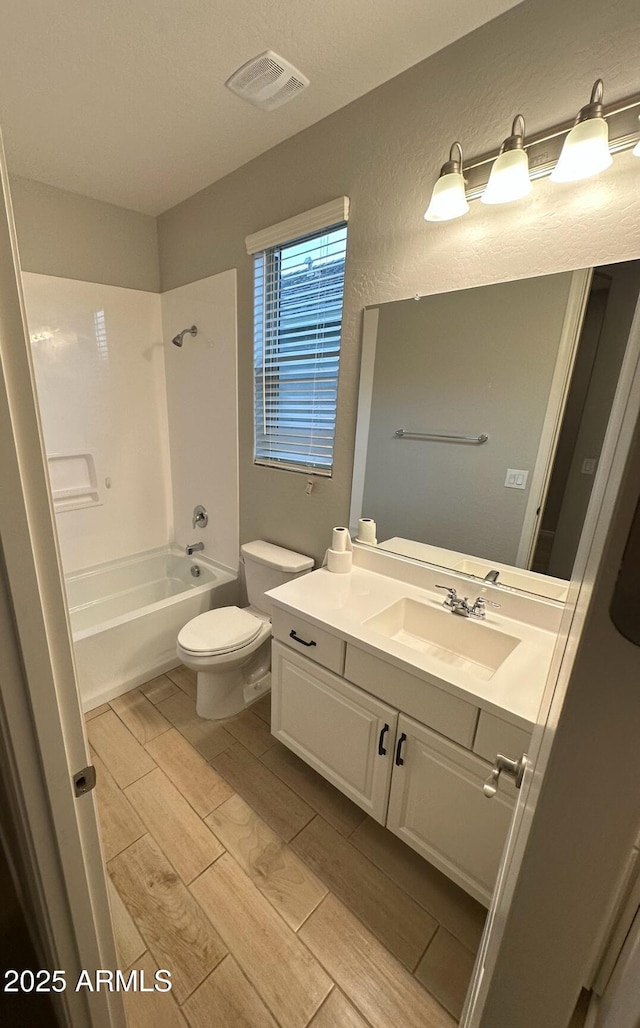 bathroom with shower / washtub combination, vanity, visible vents, toilet, and wood tiled floor
